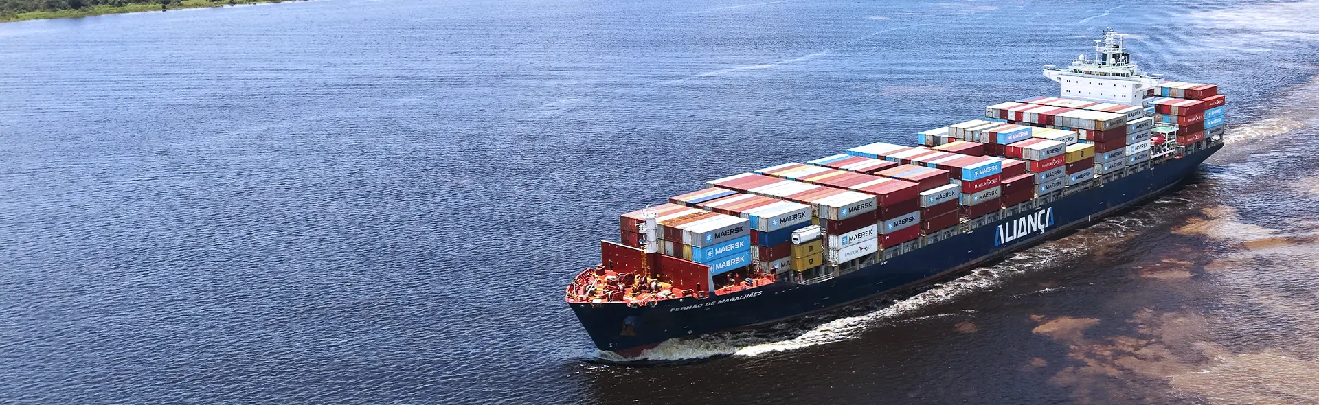 Navio porta-contêineres da Aliança navegando em rio da Amazônia.