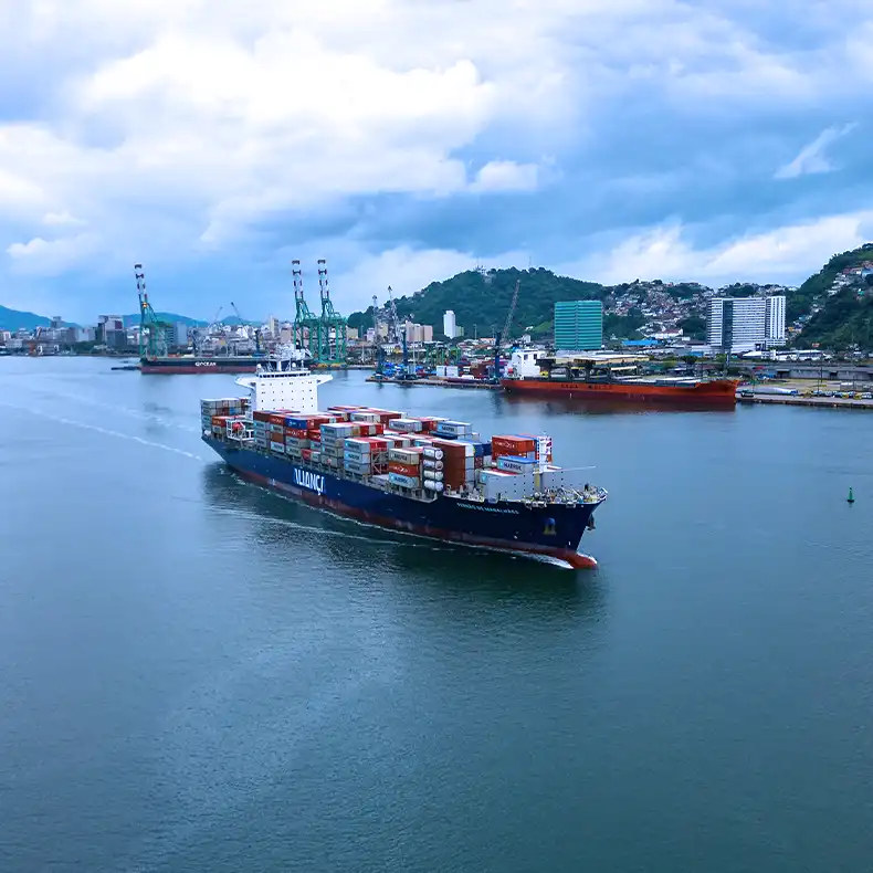 Aliança vessel loaded with containers seen from above, alongside a tugboat