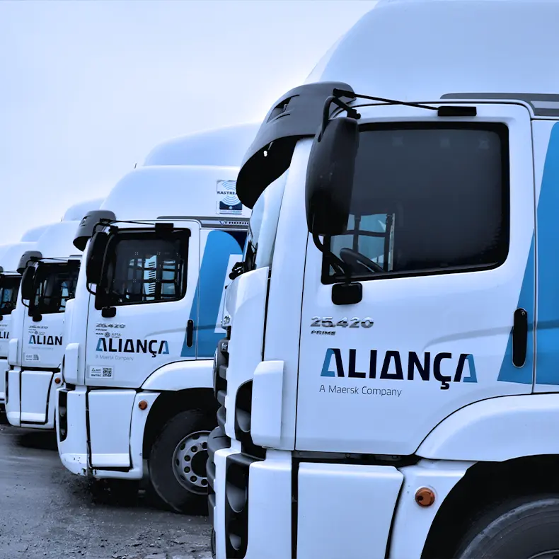 Caminhões da frota Aliança estacionados lado a lado.
