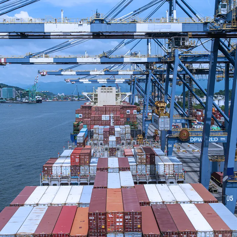 Pórticos do terminal sobre os contêineres no convés de um navio atracado.