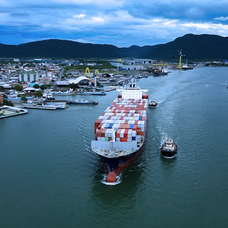 Navio porta-contêineres da Aliança deixando o porto acompanhado por rebocadores.